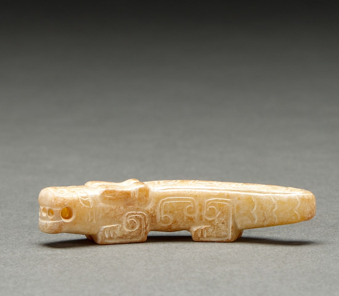 He Tian Yu Beast before the Ming Dynasty: Pre-Ming Hetian Jade Beast. Imposing in presence and radiant with vitality, the piece stands 1.5 cm tall, is 6 cm wide, and weighs 14 g. The jade is warm and translucent with naturally mellow markings