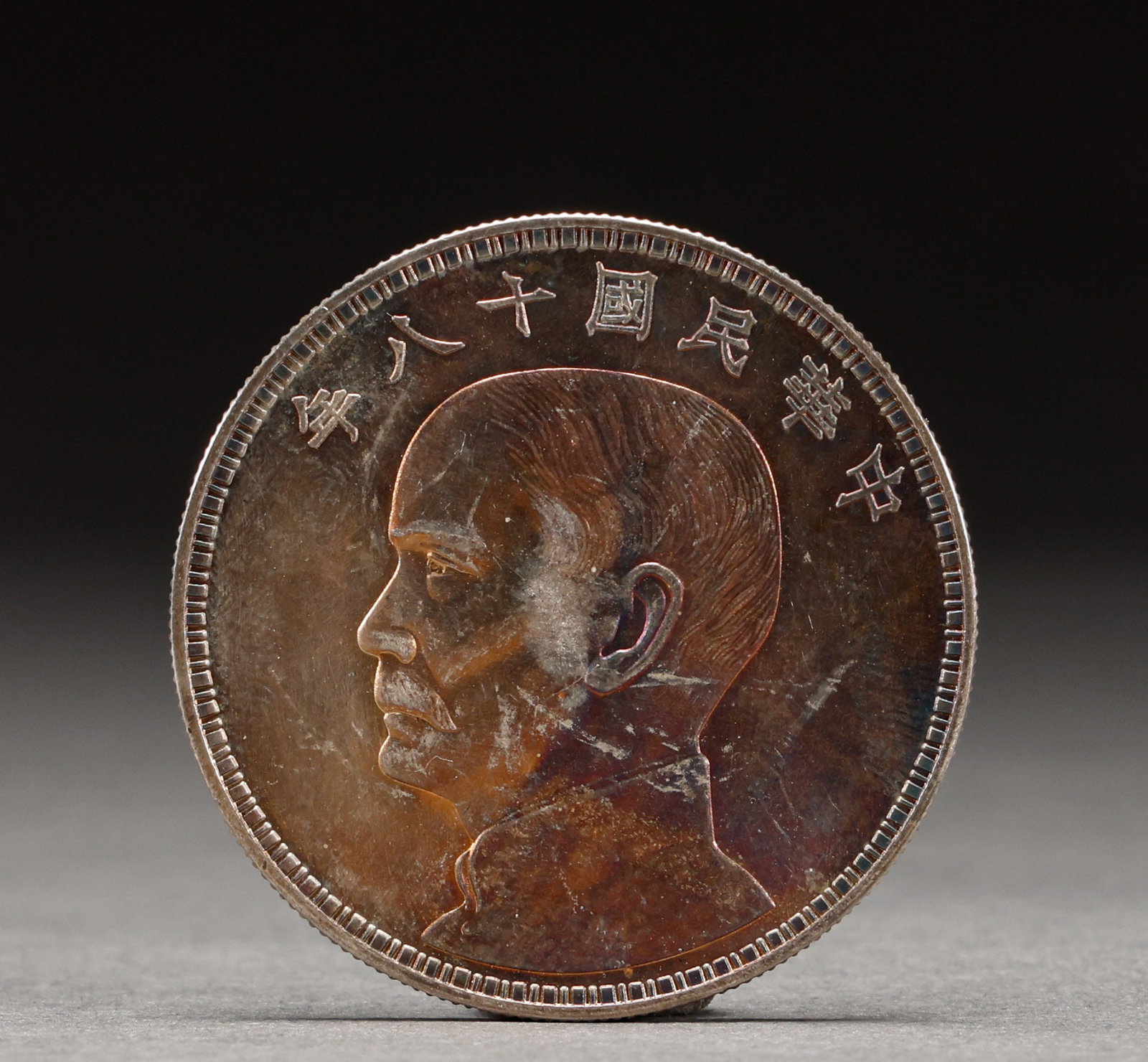 Silver coin of Sun Yat sen statue in the 18th year of the Republic of China: Republic of China Year Eighteen Sun Yat-sen Silver Coin. Steeped in antique charm, its patina warm and mellow, the piece is 3.9 cm in diameter. The inscriptions are bold, the rims regular, and the coi