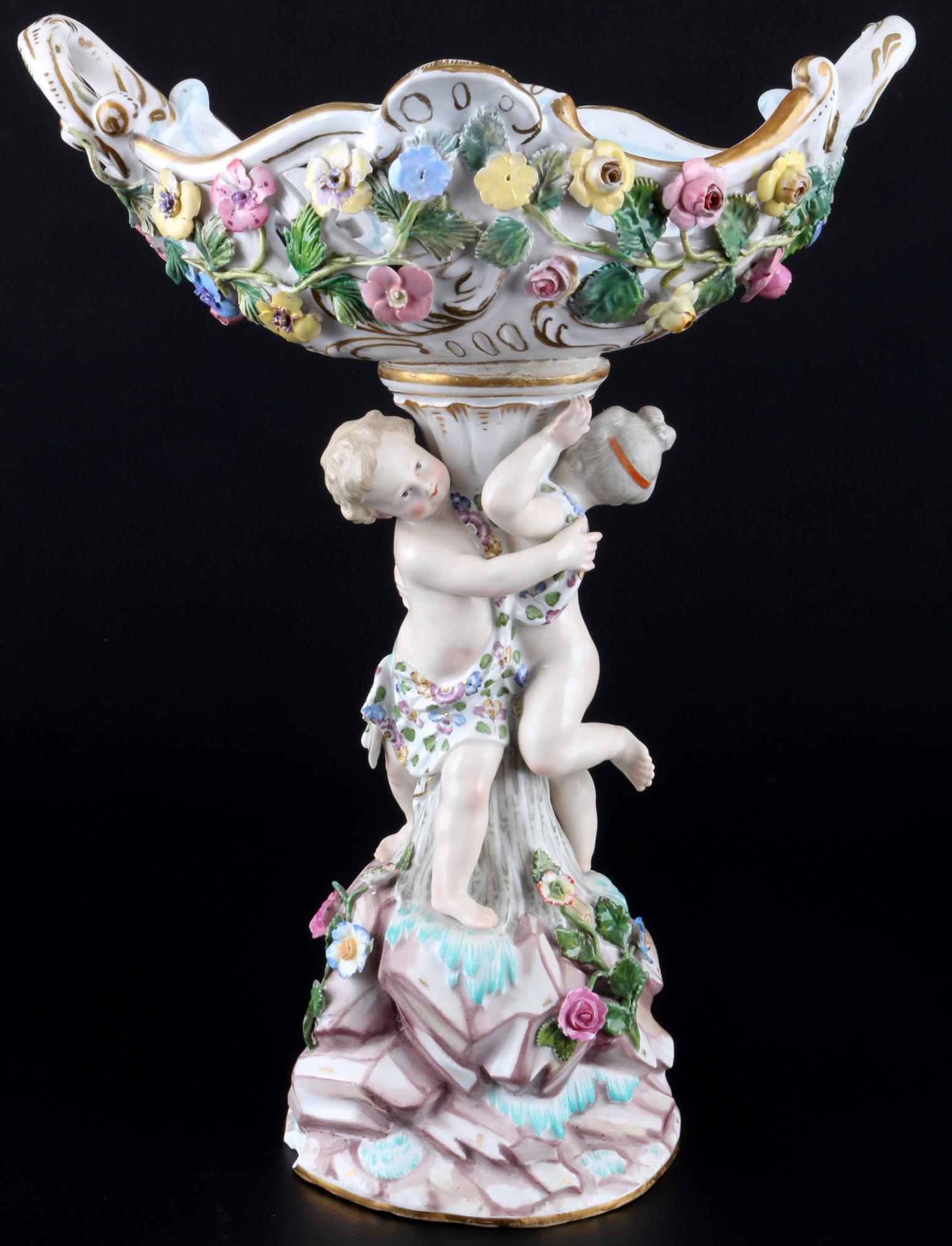 Meissen centerpiece with cherubs and flowers 1st choice, figÃ¼rlicher Tafelaufsatz mit Putten und: porcelain, blue sword mark 1st choice, knob mark 1860-1924, design by Johann Joachim Kaendler (1706-1775), figural centerpiece with two putti, cutwork with numerous flowers, H 29.5 cm x W 22 cm x D 13