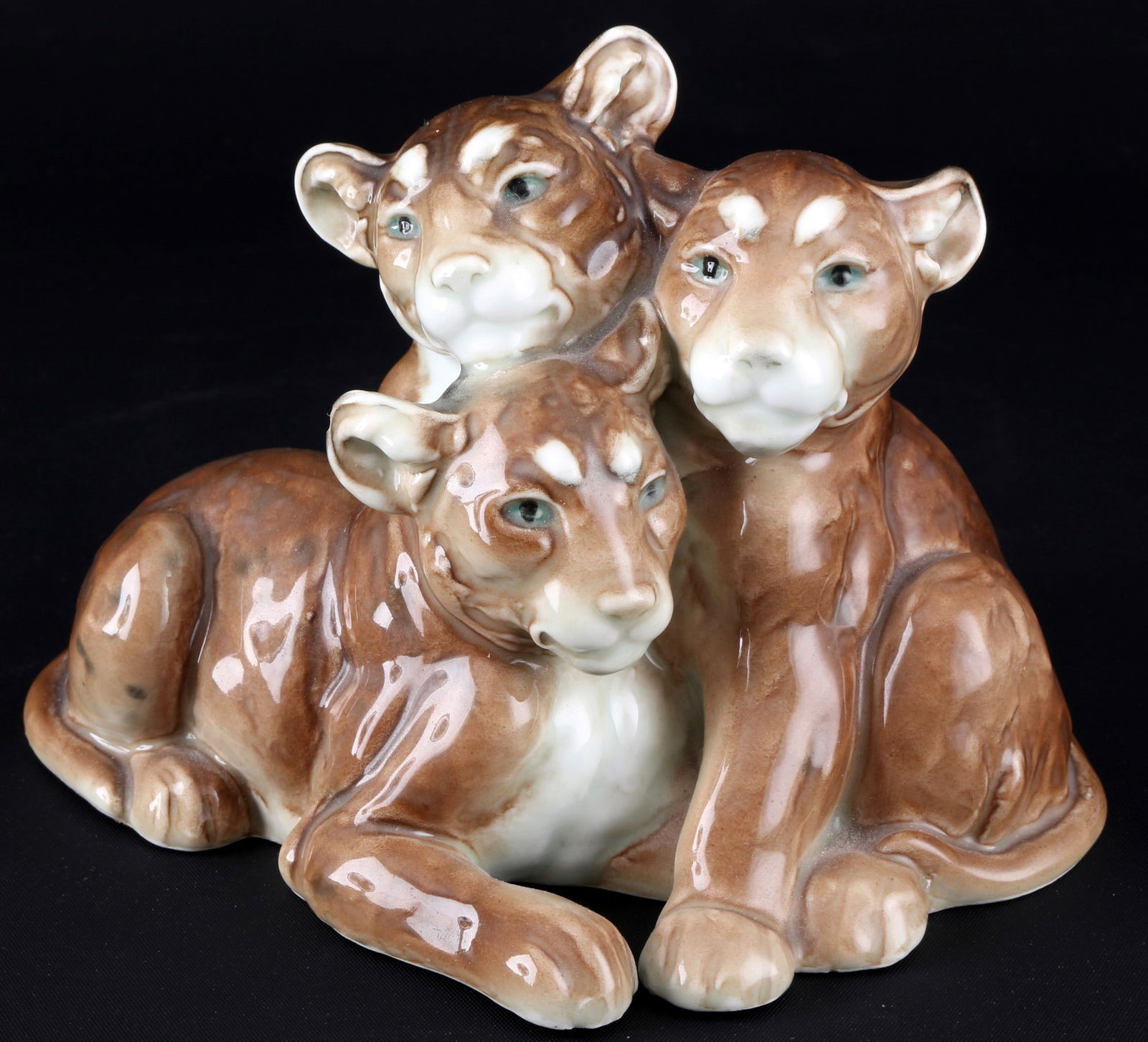 Karl Ens group of lion cubs - August GAUL,: porcelain, green mill mark, design after August GAUL (1869-1921), 3 lion cubs naturalistically set on a base, H 11.5 cm x L 14 cm x W 17 cm, chip on one ear