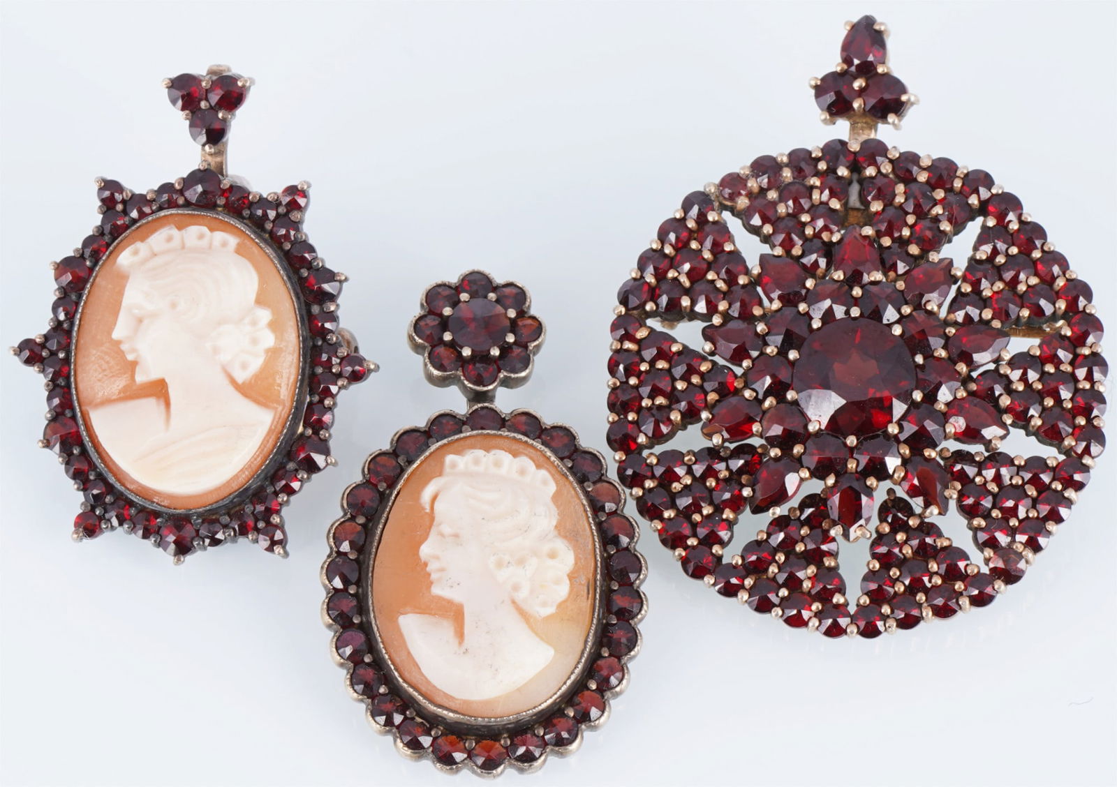 Bohemian Garnet Jewelry, 3 Pendant Cameo: Two antique cameo pendants with female profiles and a round pendant/brooch with Bohemian garnets, including rose-cut and tombac-set stones; cameo pendant approx. 35 mm x 22/25 mm (width) and brooch 34