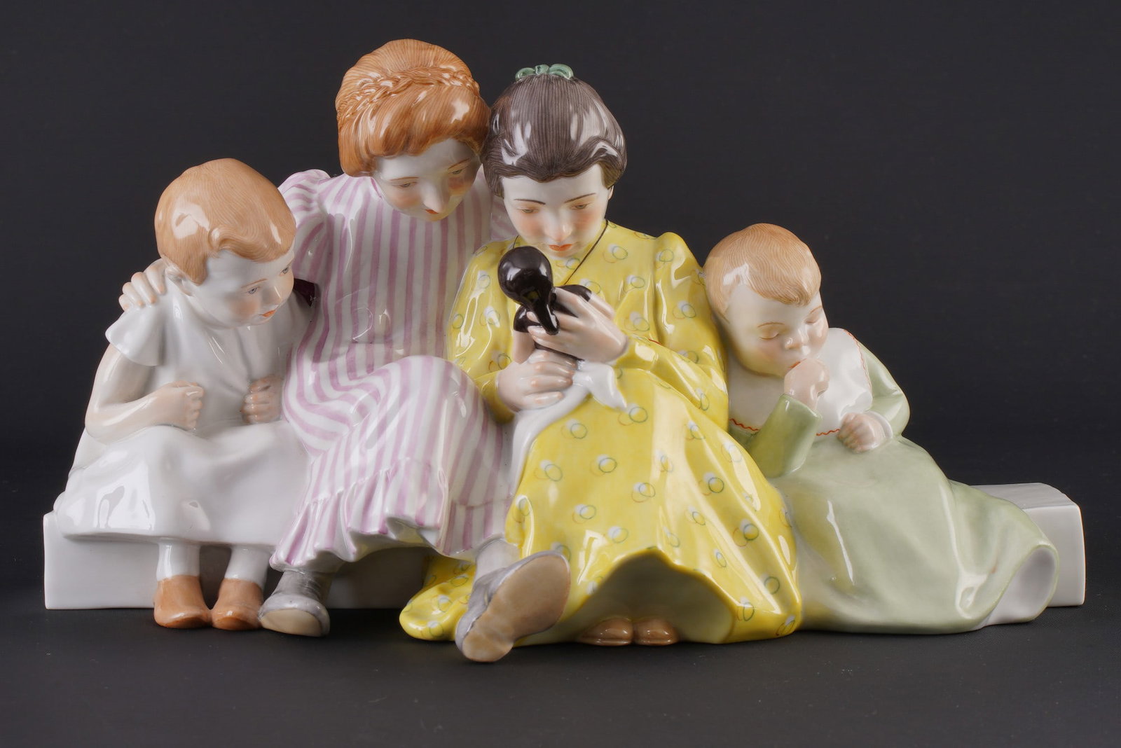 Meissen Hentschel Child children's group with doll 1st choice - Konrad HENTSCHEL,: porcelain, blue sword mark 1st choice, designed by Julius Konrad HENTSCHEL (1872-1907) around 1905, depicting four children with a doll sitting on a beam, model no. 73373, painter's no. 2239, manufact