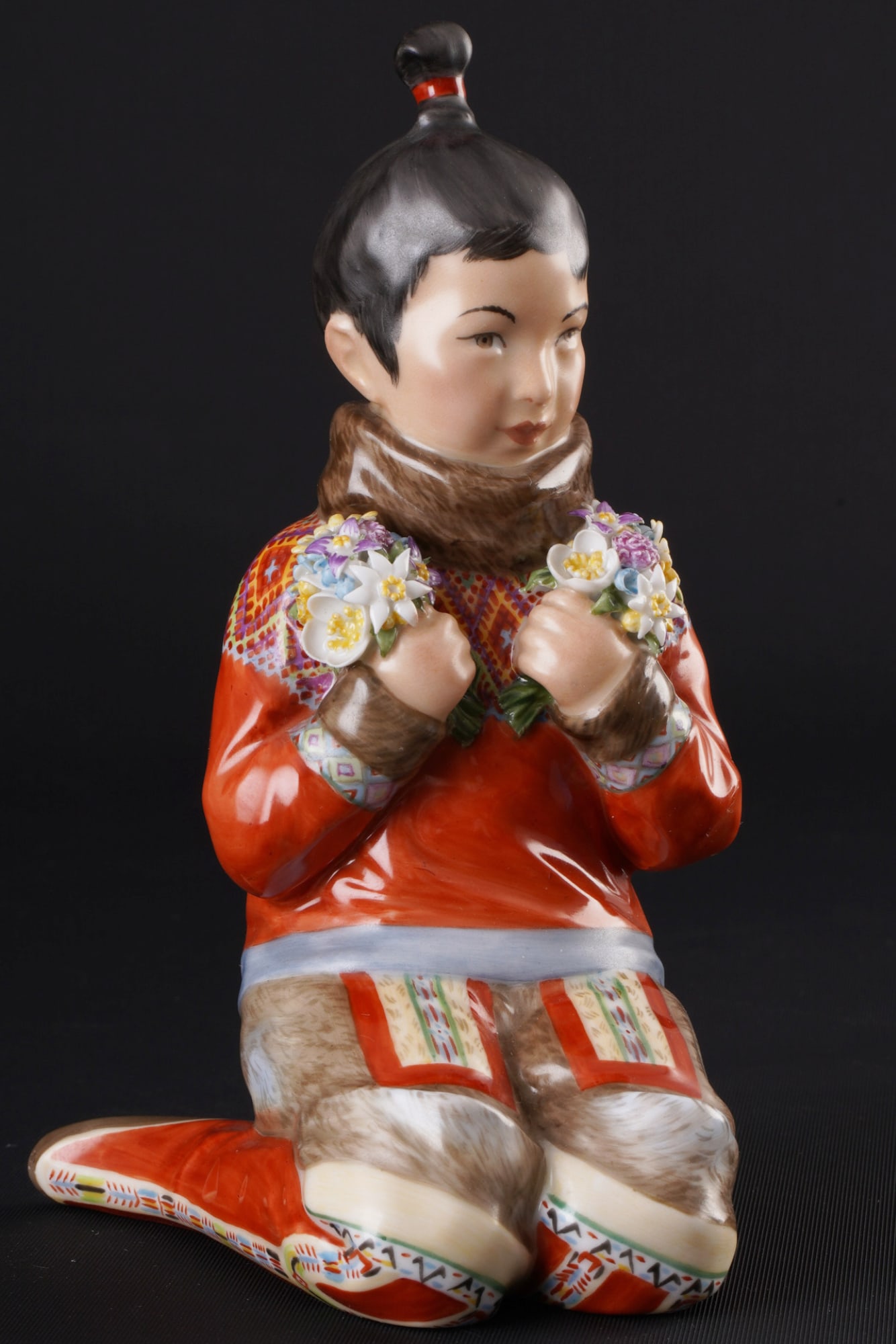 Royal Copenhagen girl from Greenland in traditional costume ? C. MARTIN-HANSEN,: porcelain, Denmark, with green crown mark and blue waves, design by Carl MARTIN-HANSEN (1877-1941), Greenlandic girl with bouquet of flowers, series of children in Danish national costumes, model no. 