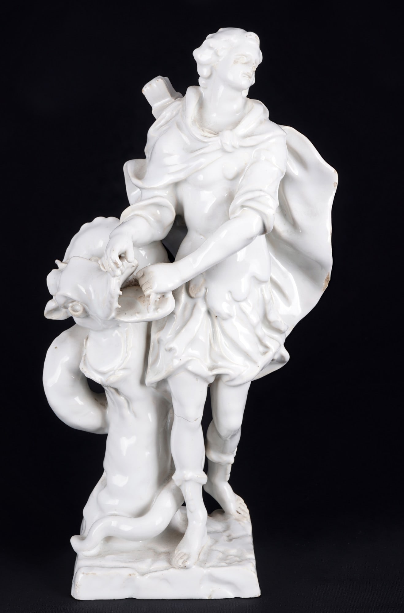 Heroic figure with serpent dragon, 18th century: White glazed ceramic, 18th century, probably German manufactory, unmarked, depicting a hero with a bow and a vanquished serpent dragon, H 24 cm x W 12 cm, crack at the knee, wear to glaze areas, sligh