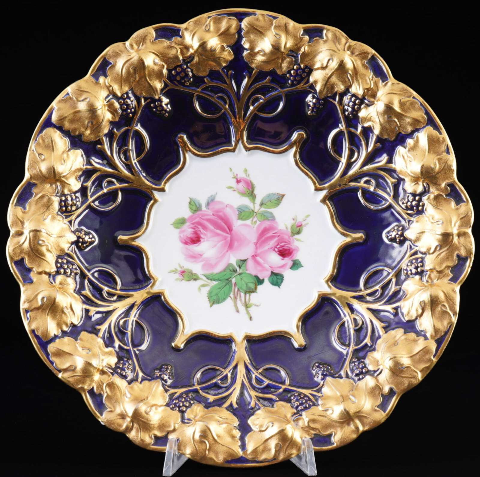 Meissen splendid bowl Red Rose royal blue with vine leaf relief 1st choice,: porcelain, blue sword mark 1st choice, Pfeiffer period 1924-1934, decor Red Rose with vine leaf relief, plate rim with royal blue ground, gold bronze, H 4.5 cm x D 26.5 cm, gold rubbed