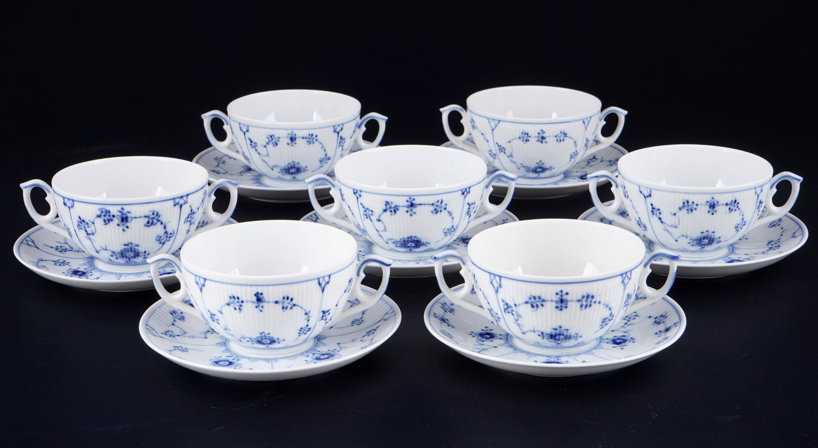 Royal Copenhagen Musselmalet 7 soup bowls #2199,: porcelain, green company mark with blue waves, decor Musselmalet Ribbed, model no. 7x soup bowls H 5 cm x D 11 cm, 7x saucers D 16 cm, abrasion on base of the cups, traces of usage