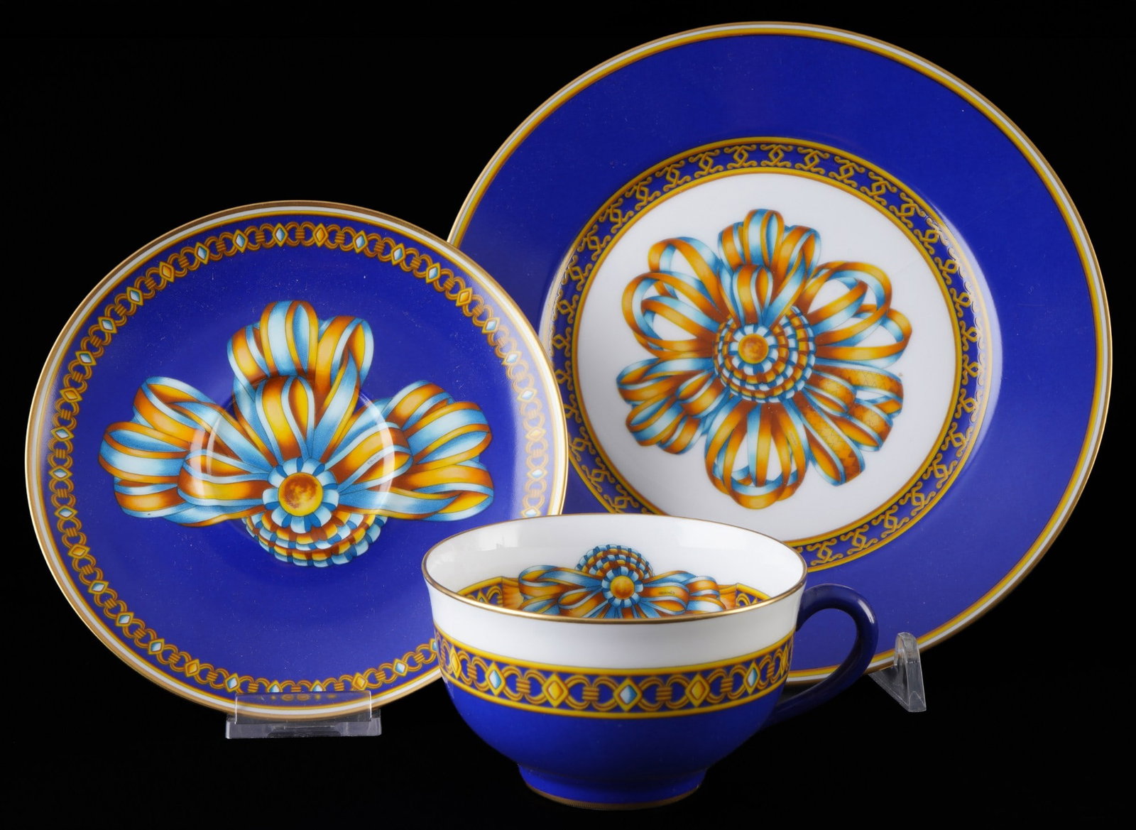 Hermes Cocarde de Soie tea place setting,: porcelain, France, Paris, blue company mark, decor Cocarde de Soie, 1x cup H 5.5 cm x D 9 cm, 1x saucer D 14 cm, 1x dessert plate D 19 cm, chip/crack in the plate