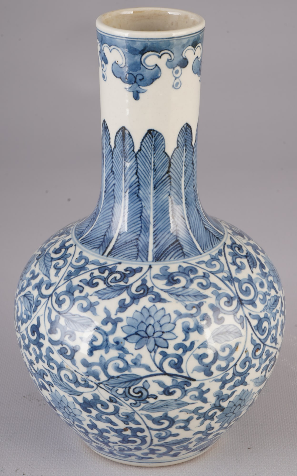 Blue and white belly vase, China, Qing Dynasty,: Porcelain, China, Qing Dynasty (1644–1911), a bulbous vase of the "heavenly globe vase" (Tianqiuping) type with a long, slender neck, decorated with intertwined lotus tendrils in underglaze blue,