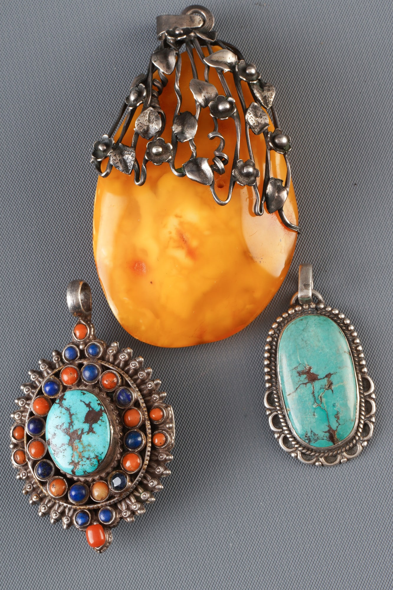 Three silver pendants with turquoise, amber and coral, Tibet,: Silver, turquoise, coral, Tibet, three silver pendants with amber, turquoise and coral, L 7.2 cm x W 4.3 cm, L 5 cm x W 3.8 cm, L 3.6 cm x W 2.4 cm