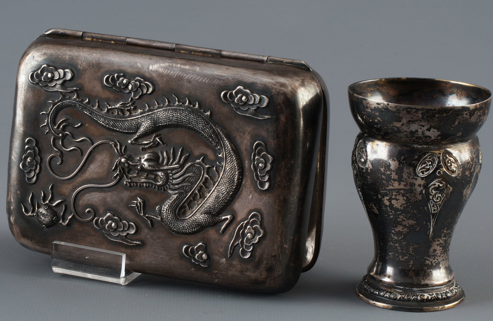 Two-piece sterling silver set, China, Republican period,: Silver, China, late Qing Dynasty to early Republican period, tobacco box with relief dragon and goblet, hallmark (Defa Lou), tobacco box H 4 cm x W 12.5 cm x D 9 cm, weight 205 g, goblet H 8 cm x D