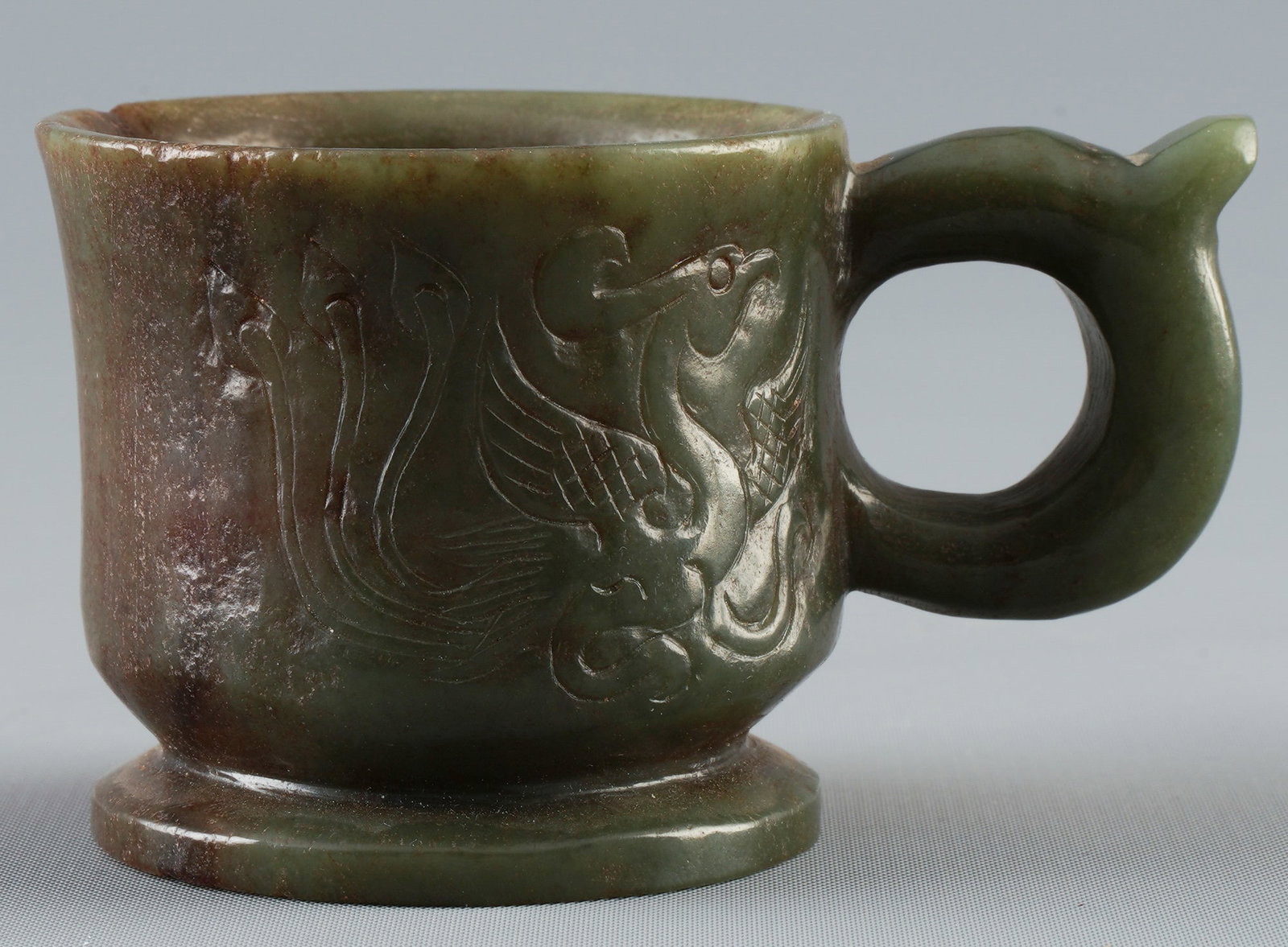 Carved Hetian nephrite jade cup, China, Qing Dynasty: Jade, China, Qing Dynasty (1644–1911), carved Hetian nephrite jade cup (dark green with brownish age patina), carved chilong handle attached to the side, surface with relief and engraving decoration