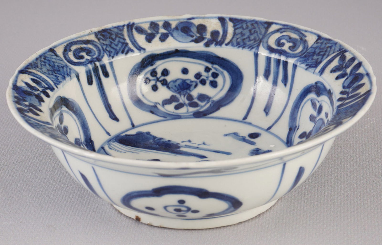 Blue and white bowl with a figurative scene, China, Ming Dynasty.: Porcelain, China, Ming Dynasty (1368–1644), blue and white bowl with a figurative scene, surrounded by several smaller cartouches with stylized flowers and decorative patterns, H 5 cm x D 15 cm, sig
