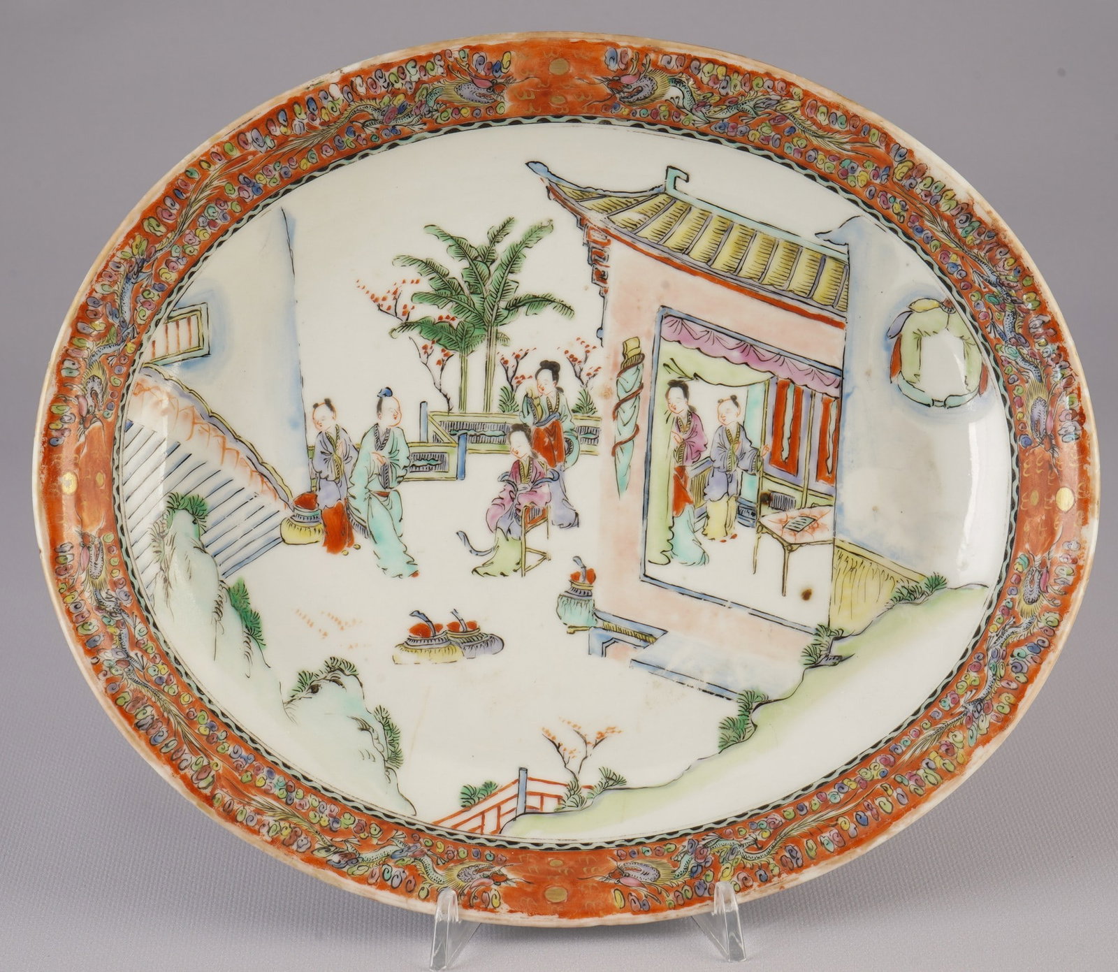 Famille Rose plate with figural scenes, China, Qing Dynasty,: Porcelain, China, Qing Dynasty (1644–1911), Famille Rose plate with a slightly flared rim, a detailed scene with figures in a garden house is painted on the white glazed surface, H 4 cm x L 28.7 cm 