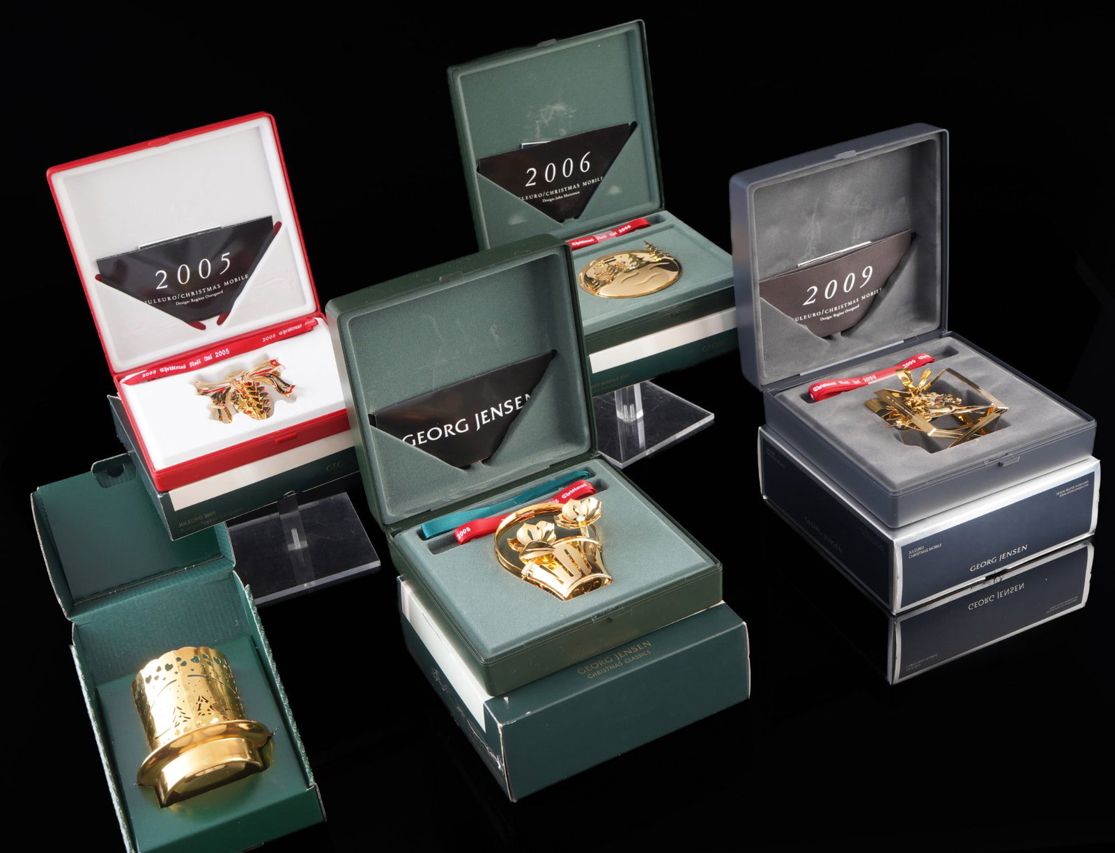 Georg Jensen Christmas Juleuro 5 Christmas collectibles,: Gold-plated brass, stamped Georg Jensen + Goldplated, 1x 2005 design Regitze Overgaard (pine cone), 1x 2006 design John Mortensen (sleigh ride), 1x 2008 design Regitze Overgaard (basket of flowers), 1