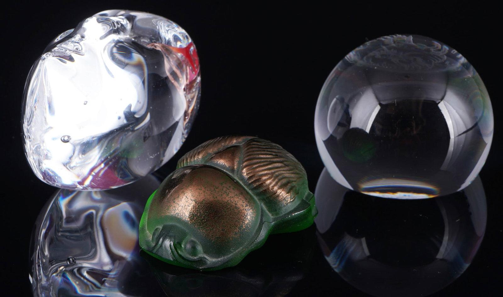 Lalique 3 paperweights,: Glass, France, signed Lalique on the stand, 1x Saracaeus in green glass H 2 cm x L 5 cm x W 4 cm, 1x female head H 5.5 cm x W 3.5 cm x D 4.5 cm, 1x dragon - sphere H 3.5 cm x D 4.5 cm