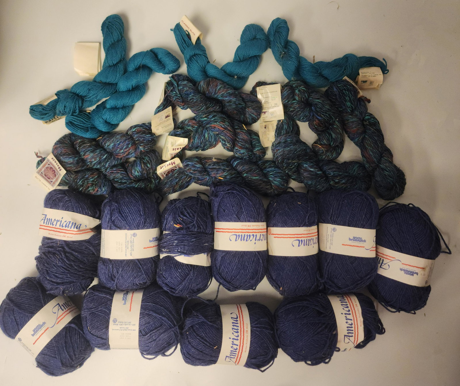 Collection of Blue Yarn: Includes: - Eleven (11) Americana - 100 gram ball, 265 yard, 60% acrylic, 20% wool, 20% ICI Nylon, machine washable navy yarn - Eight (8) Classic Elite - Mosaic - dry clean only, 65% wool, 30% rayon, 