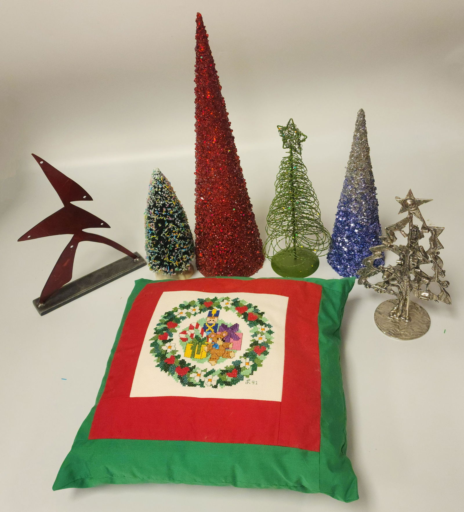 Collection of Various Decorative Trees and Decorative Handmade Pillow: Trees for all featuring - an abstract ornament hanger, a multicolored frosted tree, a glittered red cone tabletop tree, a green glittered woven tree, a blue and silver sparkely tree, and a Don Drumm p