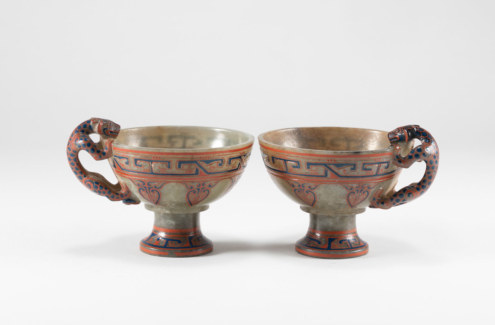 A pair of Han Dynasty lacquer carved dragon ear cups: H:6.5cm D:7.7cm