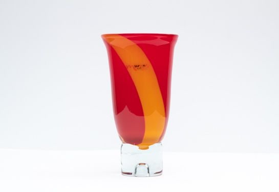Murano Vase - Glass object: Elegant Murano art glass vase featuring a vibrant red body with a bold orange swirl, set on a clear glass base. Hand-blown in Italy, this piece combines timeless Venetian craftsmanship with modern dec