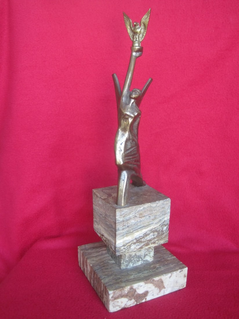 Bronze Italian Art Deco Sculptue: Liberta, Unknown Italian Artist – A striking Art Deco bronze sculpture depicting an elegant female figure raising a bird aloft, symbolizing freedom and transcendence. The stylized form, with its