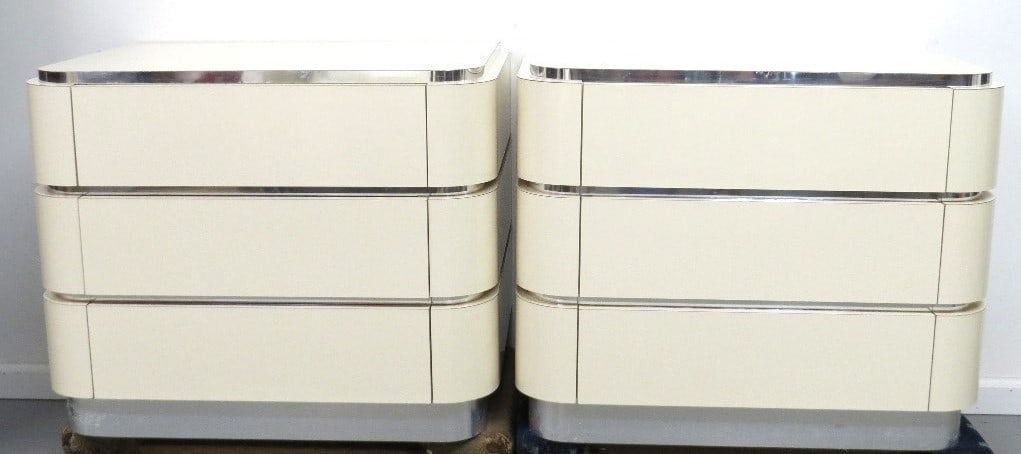 Pr. White Laminate on Hardwood Retro Night Stands: Art deco styling on these light cream w/chromed banding 2 drawer night stands. 30" wide, 21" deep, 24.5" height. Very solid, wood framing. Good condition