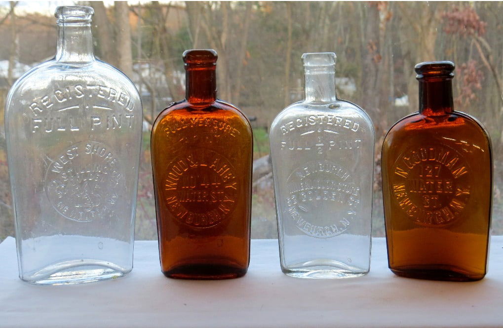 Lot of 4 c.1875-1900 era Newburgh, NY Saloon Flasks: Four (4) rare Newburgh, New York adveritising whiskey strapside flasks, 3 in half-pint size, one in pint size. All in very good condition, includes: West Shore Distilling Co, Newburgh Pint in Clear; W