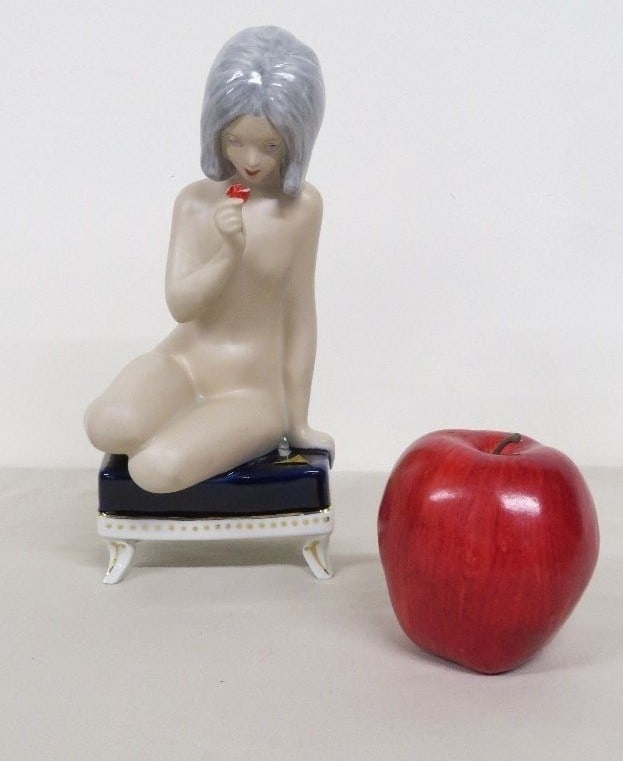 Royal Dux Sultry nude woman with small rose in hand: A very sultry Royal Dux porcelain figurine, made in Czechoslovakia of a young lady seated nude on a blue pillowed chair, holding a small red rose or flower in her right hand. Well done as her gaze is 