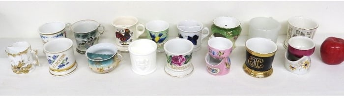 A collection of 18 antique barber shaving mugs