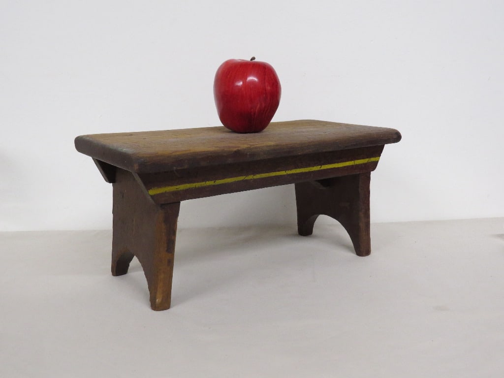 A primitive jackboot stool w/yellow stripe: A primitive stool with jackboot feet and yellow stripe. Old collection sticker completely faded on one end. Measures 14" wide, 6.75" depth and 6.25" in height