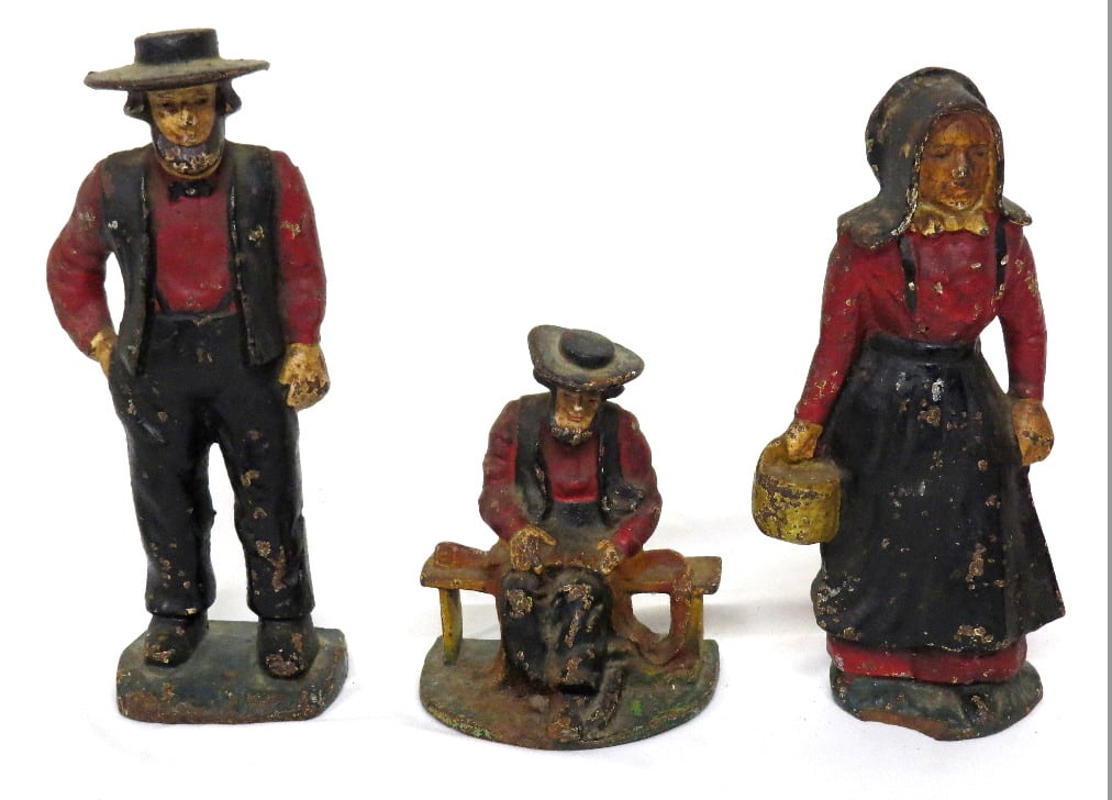 Lot of 3 Cast Iron Amish Doorstops Early 20th C.: Lot of 3 cast iron doorstops in original paint, Amish folk standing 5", 8" & 9" in heights. Figure of a woman has a small front side base chip.