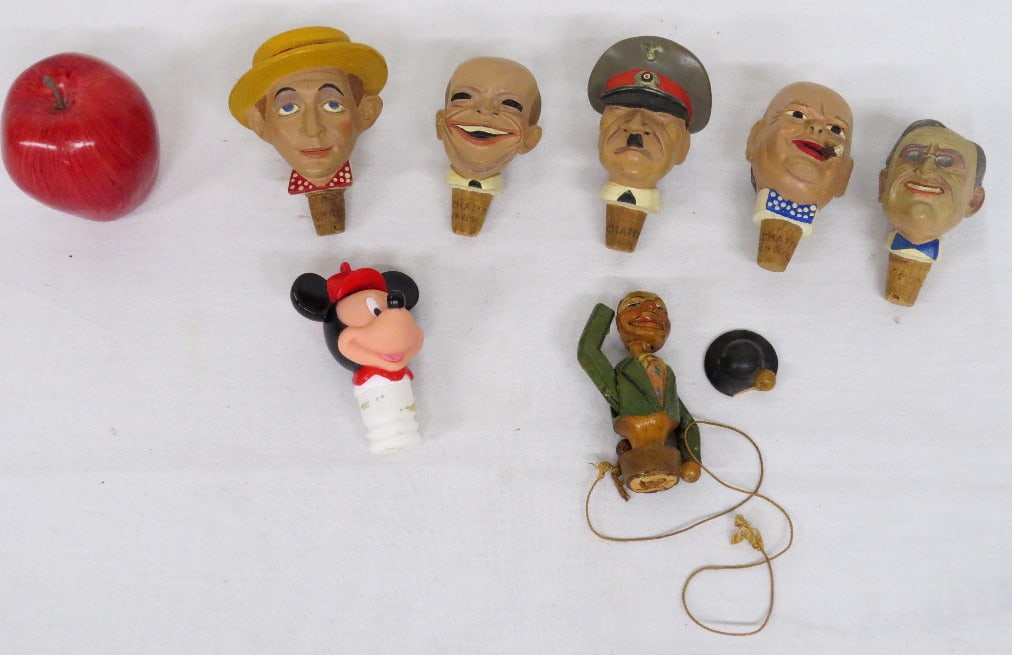 Ceramic & Carved Wooden Caricature Bottle Stoppers WWII Era: A group of ceramic and carved bottle stoppers, primarily WWII era including caricatures of Adolph Hitler, FDR, General Eisenhower, Winston Churchill, Humphrey Bogart, etc. Carved wooden stopper is mec