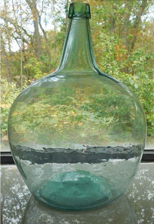 Pontiled Flowerpot Shaped Aqua Demijohn 19th C.: Reminding us of a squat flowerpot form is this blown and pontiled 19th C. Demijohn in aquamarine. No damage, 18" in height, 13" in diameter. Applied tapered collar lip treatment in a color that contra