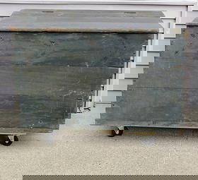 An Early Large Sized Country Blanket Box / Firewood Box in Old Blue Paint: A 19th C. square nail constructed primitive box with hinged lid in old blue finish. Originally built in or against a corner or wall it retains the old leather strap handles, but is unpainted on the ri