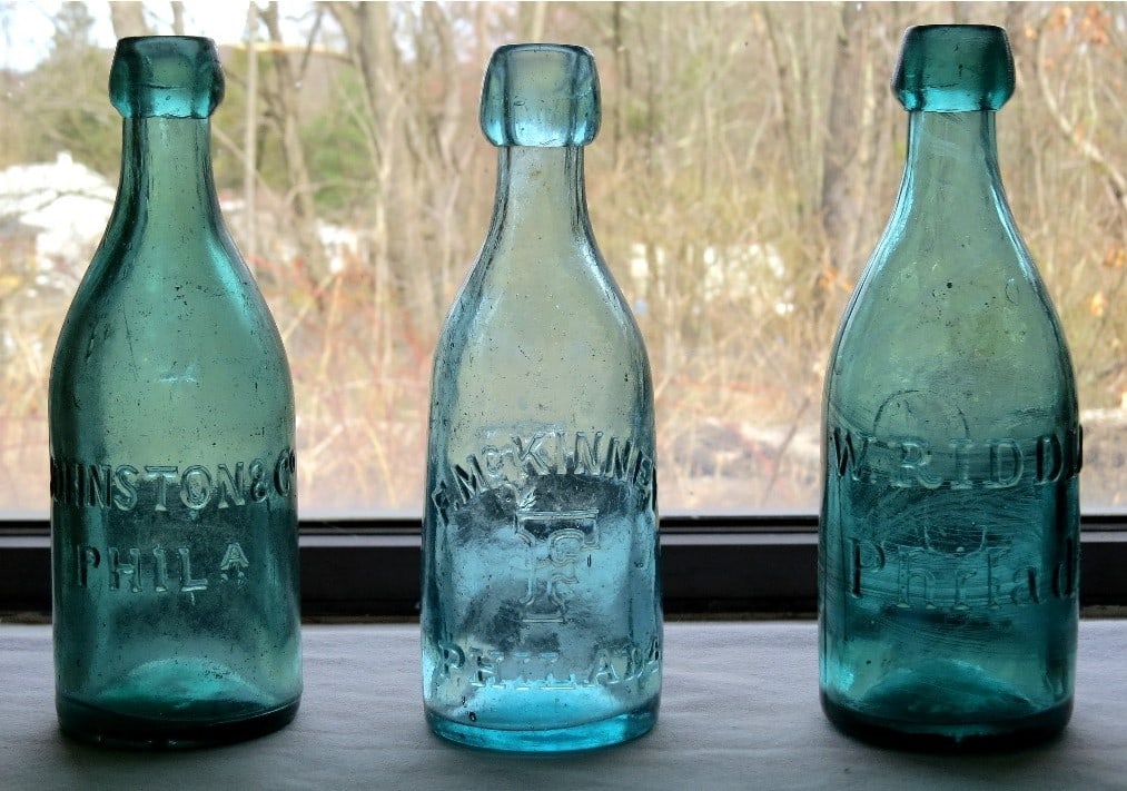 Lot of 3 Philadelphia Colored Soda's - One Iron Pontiled: Three Philadelphia c.1850-70's Squat colored sodas, all in shades of teal green. Includes a Johnston's Philada w/embossed star on reverse shoulder, smooth based; A F. McKinney "F" Monogram Smooth Base
