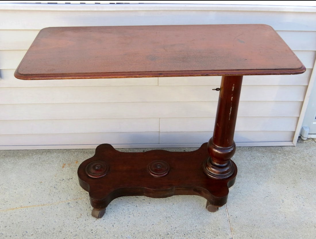 A Victorian Walnut Hospital / Invalid Bed Table: A Victorian Era rolling hospital or invalid bed table with adjustable height tray. Original wheels replaced at some point years ago giving it better movability. Table is 38" long by 18" wide, current
