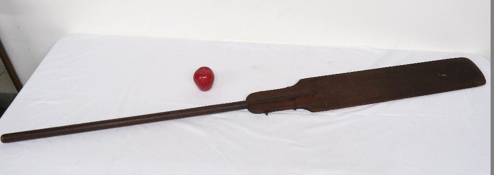 A 19th C. Oar With Traces of Old Red Paint: A 19th C. two piece oar with traces of old red paint in the graining, quite interesting in construction with the blade mounted to the stem via two bolts that pass side to side. Measures 69" long overa