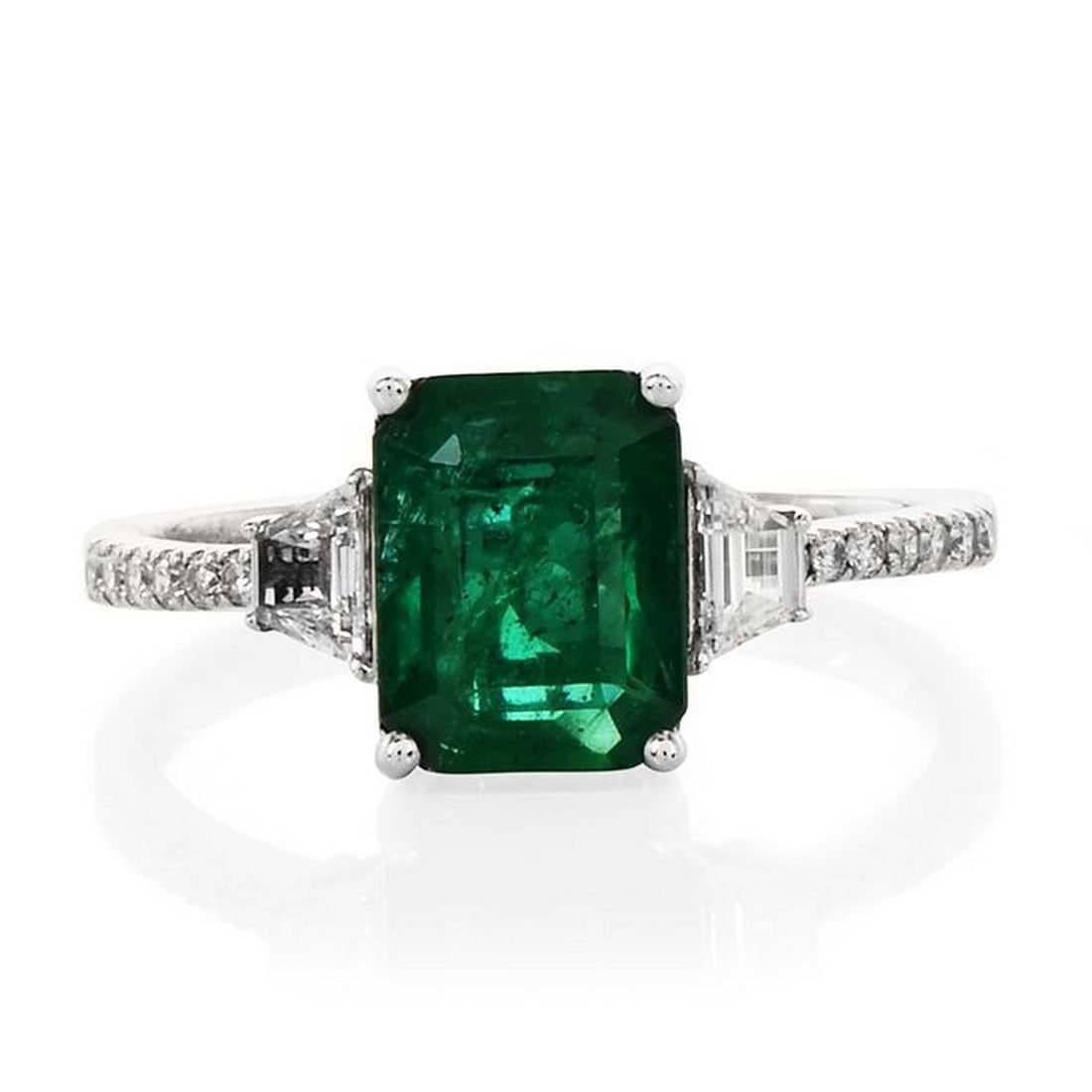 Deep Green Emerald Diamond 18K Gold Engagement Ring: This Beautiful 18K Emerald ring features an Emerald cut Emerald that is Measuring 8.89 x 6.9, and weighing approx. 2.03 carats. It flanks from either side a trapezoid shape diamond and runs down On ea