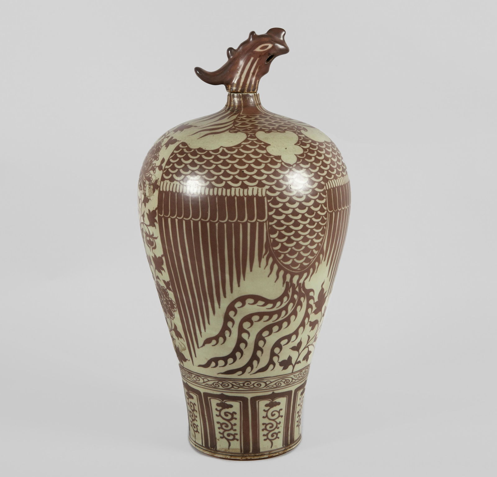 VASE WITH STOPPER IN ENAMELED PORCELAIN. FOLLOWING: VASE WITH STOPPER IN ENAMELED PORCELAIN. FOLLOWING MODELS MING DYNASTY, CHINA 50 cm high. With a stopper representing the head of a phoenix, whose body is represented on the back of the vase. Decorati