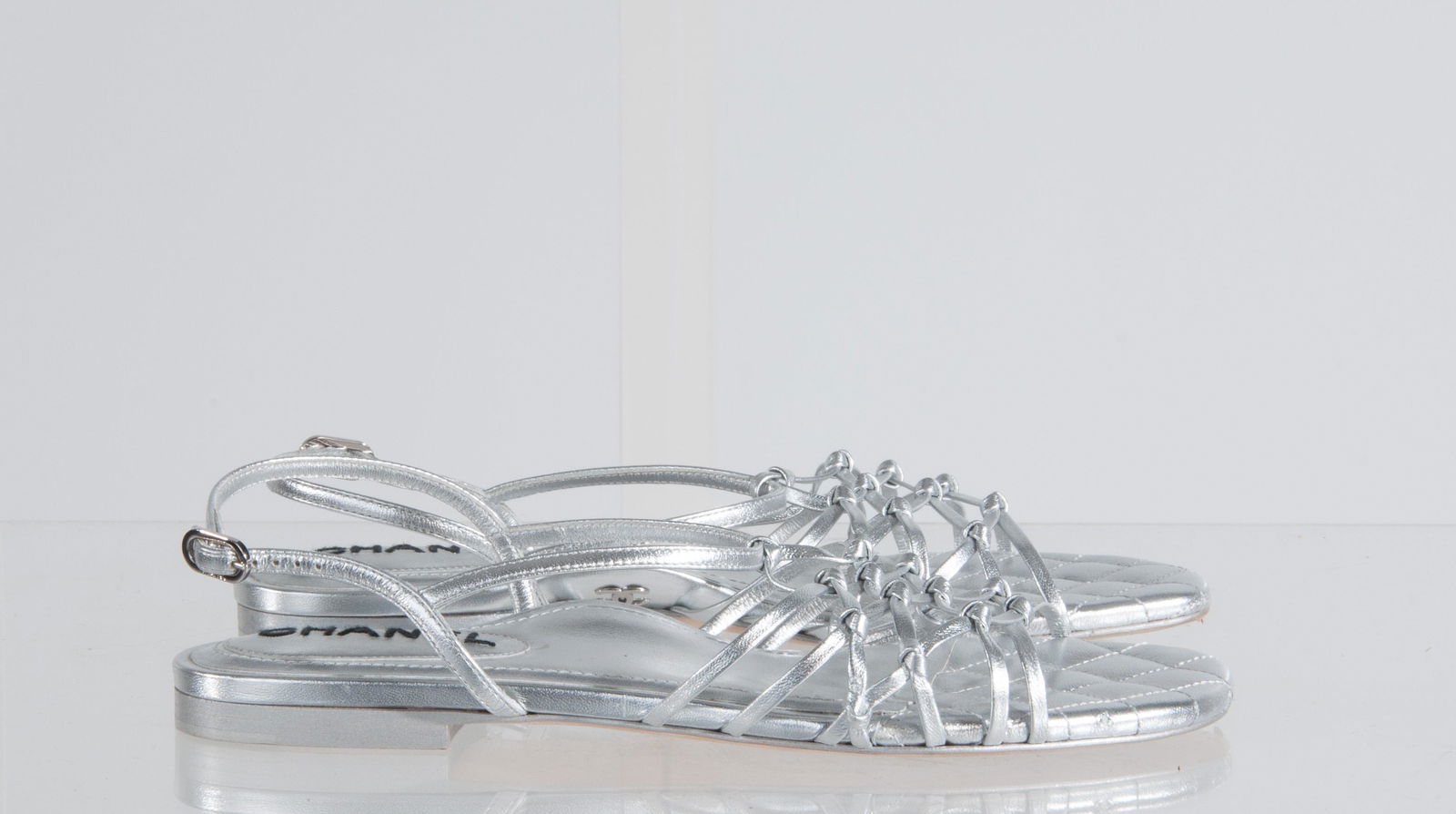 Chanel Silver Leather Quilted Strap Flat Size 38: Chanel Silver Leather Quilted Strap Flat Size 38; Pointed Toe, Knotted Woven Leather Gladiator, Strap on Heel; Heel h:0.5