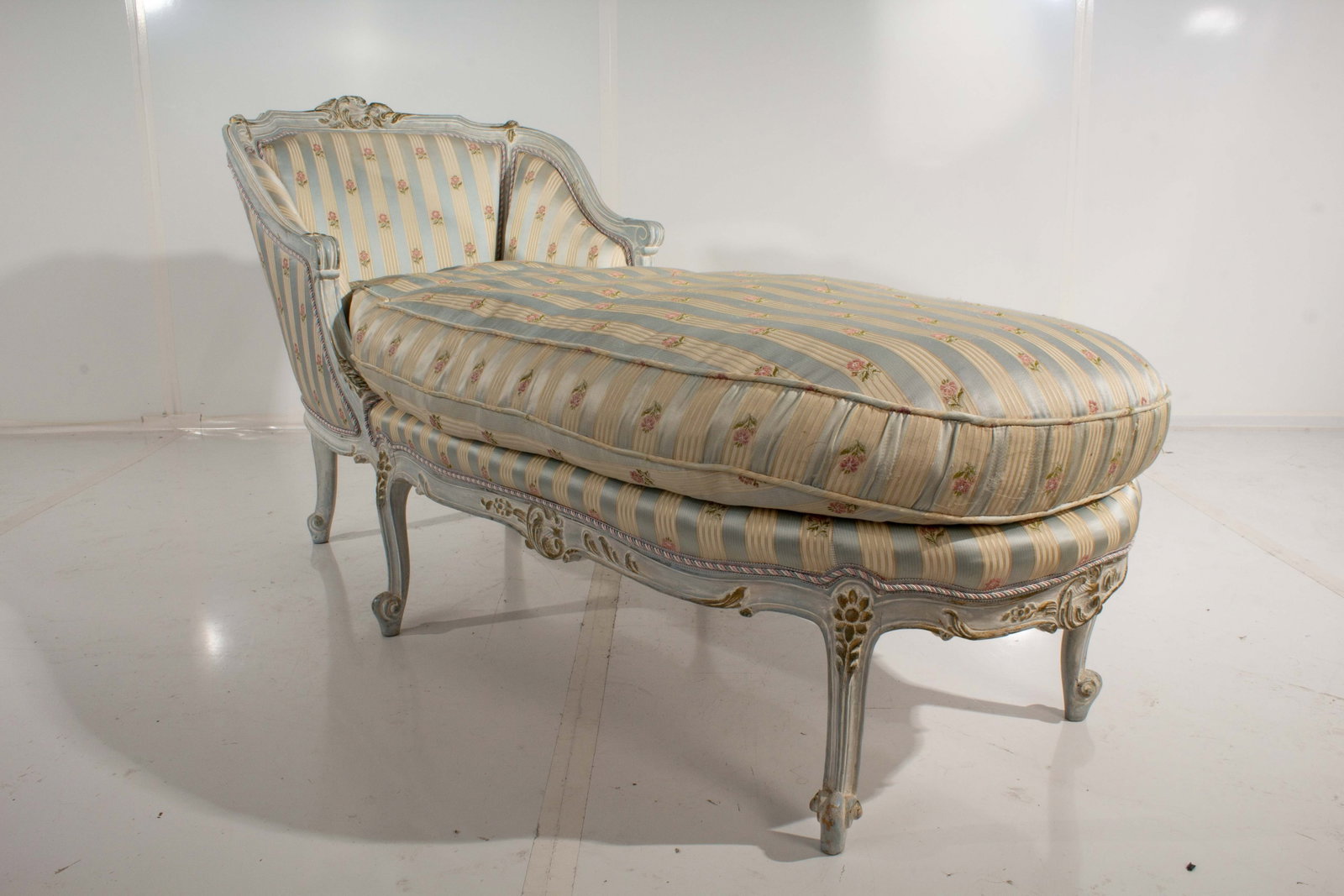 Floral Chaise Lounge Chair: Embroidered upholstery. Frayed needlepoint in some locations as well as some fraying to fabric along sidewall of cushion. Some paint wear. Minor loosening of joinery along the skirt. Fabric fading. Cu