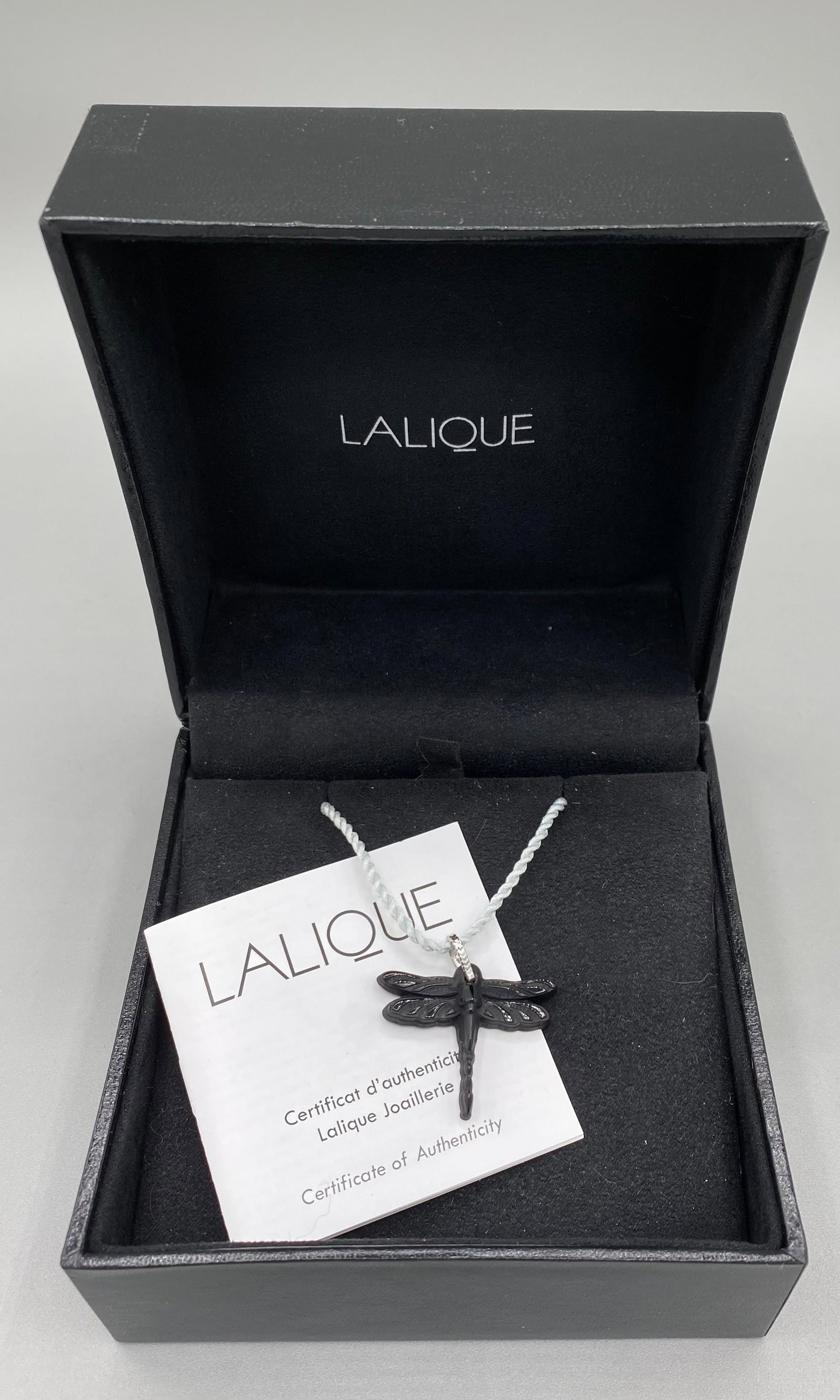 Lalique Black Dragonfly Pendant Orig Box: This Lalique Talisman Libellule (dragonfly) Noir (black) is signed Lalique. The bail is marked .925 and has French silver hallmarks. The dragonfly stands 1” tall and has a wingspan of 1 1/4&rdqu