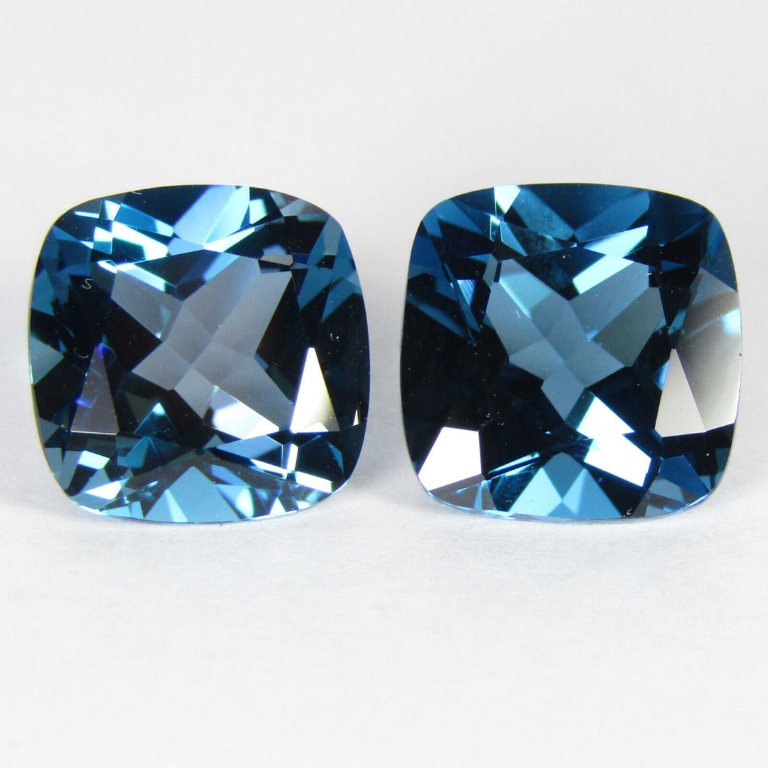 Natural London Blue Topaz 12x12 MM Cushion Cut Gemstone Pair: Natural London Blue Topaz 12x12 MM Cushion Cut Gemstone Pair Gemstone : London Blue Topaz Stone Shape : Cushion Stone Cutting Type : Faceted Cut Stone Weight : 20.30 Carats Stone Measurement :