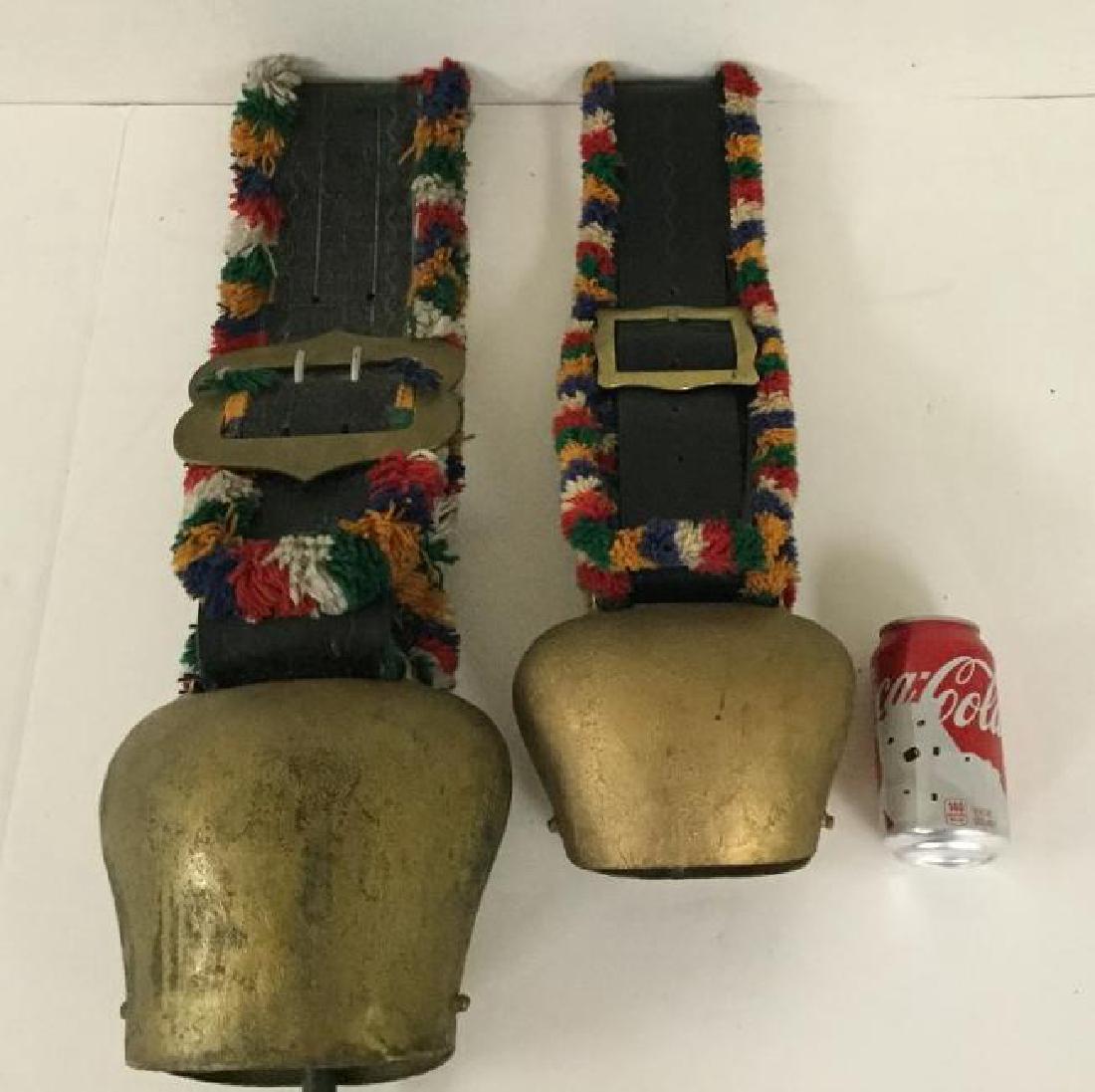 2 SWISS LARGE COW BELLS WITH LEATHER STRAPS, SMALLER: 2 SWISS LARGE COW BELLS WITH LEATHER STRAPS, SMALLER BELL MEASURES 6 1/2" TOP TO BOTTOM, LARGER BELL MEASURES 8" TOP TO BOTTOM, OLDER GOLD PAINT OVER IRON BELL, AS PICTURED