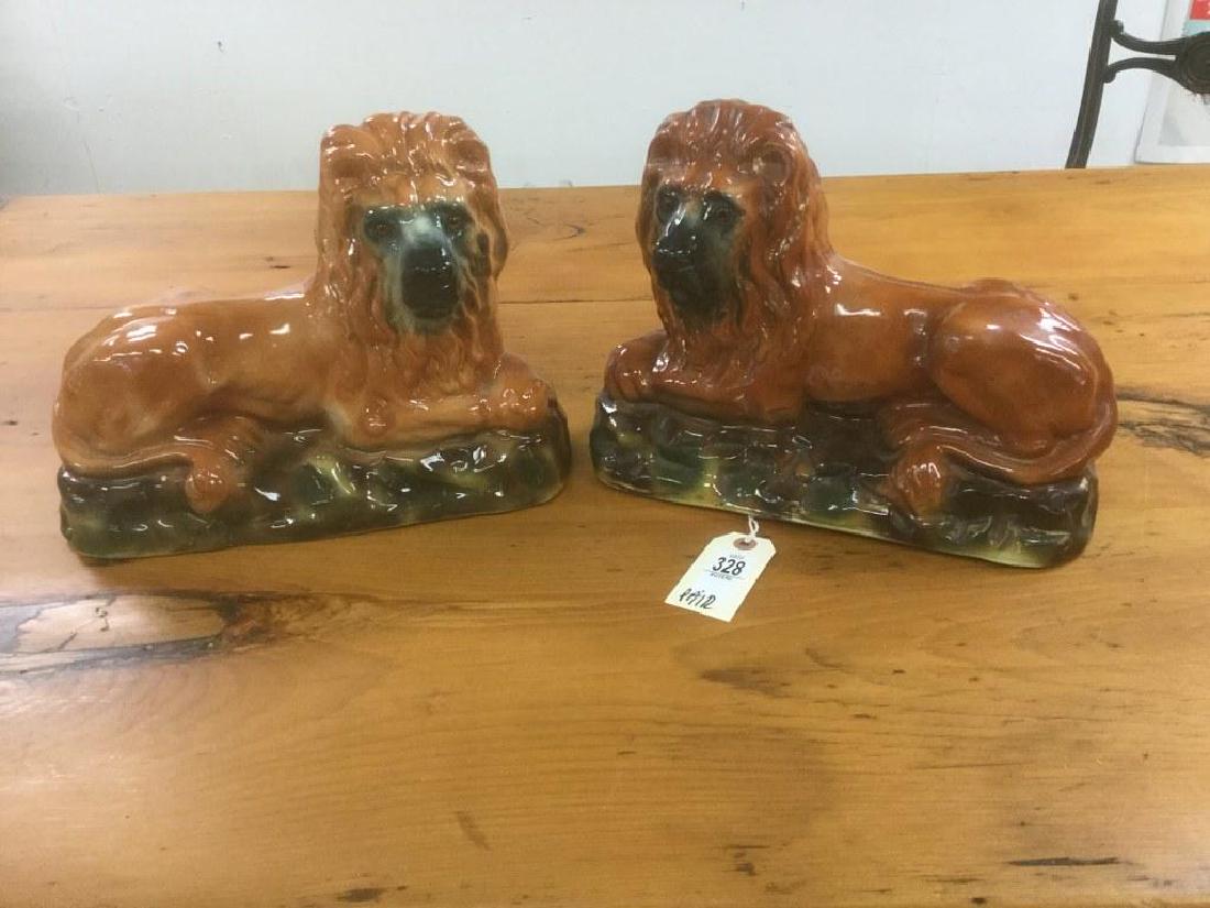 PR. STAFFORDSHIRE RECLINING LIONS, ONE HAS A LITTLE: PR. STAFFORDSHIRE RECLINING LIONS, ONE HAS A LITTLE DEEPER COLOR THAN THE OTHER, GLASS EYES, AND ONE HAS HAIRLINE BY HOLE ON UNDERSIDE. MEASURE 13" LONG. FROM GENTLEMANS COLLECTION WE ARE SELLING.