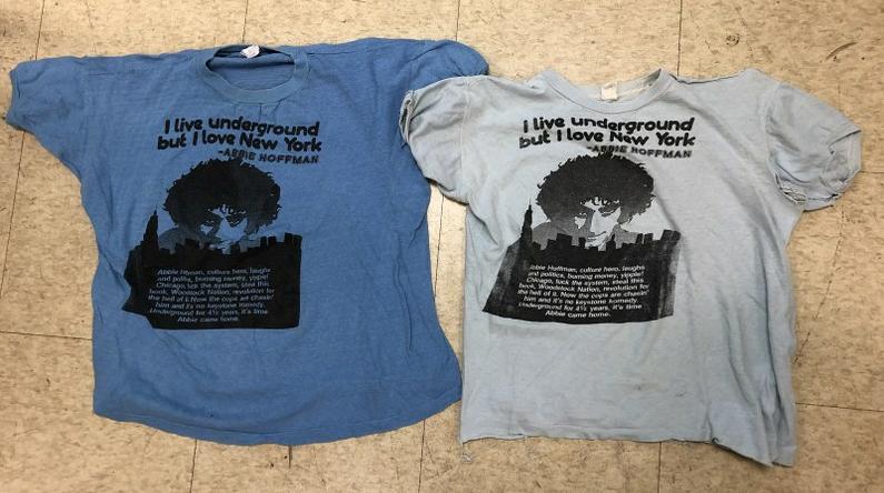 (2) ABBIE HOFFMAN 1970'S TEE SHIRTS - I LIVE: (2) ABBIE HOFFMAN 1970'S TEE SHIRTS - I LIVE UNDERGROUND BUT I LOVE NEW YORK. SIXE APEARS TO BE WOMANS 12, WHICH I MADE OFF ONE LABEL, ONE IN BETTER CONDITION THAN THE OTHER. FROM WOODSTOCK, N.Y. HOME