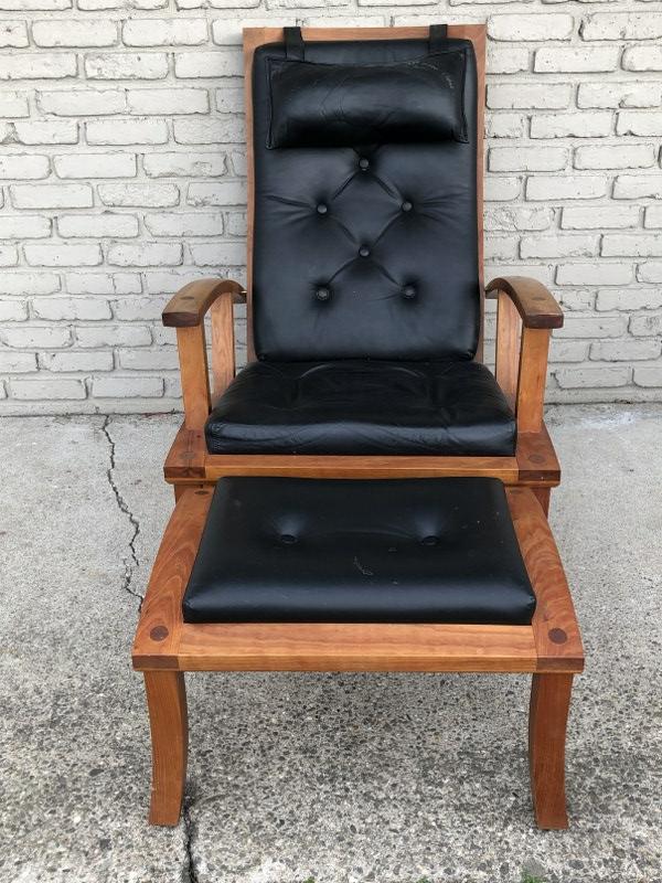 THOMAS MOSER LOLLING CHAIR AND OTTOMAN IN BLACK: THOMAS MOSER LOLLING CHAIR AND OTTOMAN IN BLACK LEATHER, CHERRY WOOD, SOLID STRUCTURALLY IN TYPICAL THOMAS MOSER FASHION, FROM ALBANY, N.Y. ESTATE OF ELDERLY GENTLEMAN, SHIFTS BETWEEN UPRIGHT AND DECL