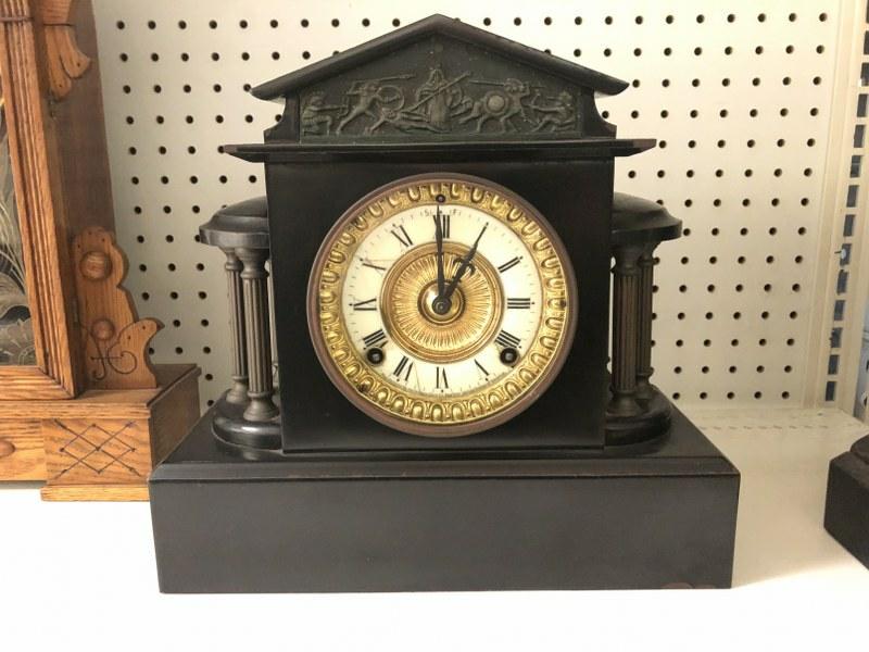 ANSONIA BLACK METAL MANTEL CLOCK, COLUMNS ON THE SIDE,: ANSONIA BLACK METAL MANTEL CLOCK, COLUMNS ON THE SIDE, RUNNING, NO KEY, HAS PENDULUM, HAS HAIRLINE ON DIAL, BODY CLEAN. MEASURES 11.25" HIGH X 12' ACROSS, FROM OLD CLOCK REPAIRMAN'S SHOP.