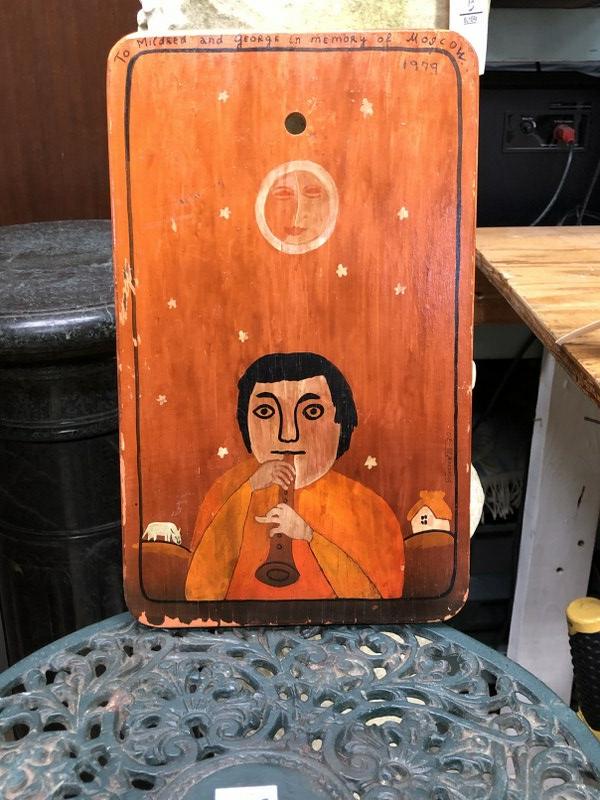 FOLKY RUSSIAN PAINTING ON WOOD TABLET OF MAN PLAYING AN: FOLKY RUSSIAN PAINTING ON WOOD TABLET OF MAN PLAYING AN INSTRUMENT, INSCRIBED TO MILDRED AND GEORGE IN MEMORY OF MOSCOW 1979. MEASURES 12" X 7". FROM ESTATE OF MILLIE AND GEORGE SCHAEFER, GEORGE WAS A