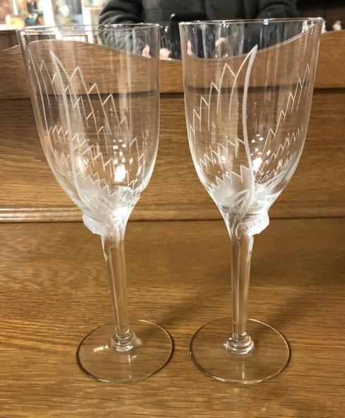 LALIQUE (PAIR) ANGEL CHAMPAGNE FLUTE GLASSES IN: LALIQUE (PAIR) ANGEL CHAMPAGNE FLUTE GLASSES IN EXCELLENT ESTATE CONDITION, SIGNED ON BOTTOMS. MEASURE 8.25" HIGH.