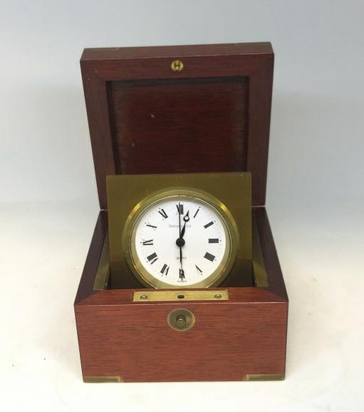 TIFFANY & CO. QUARTZ TRAVEL CLOCK IN MAHOGANY CASE,: TIFFANY & CO. QUARTZ TRAVEL CLOCK IN MAHOGANY CASE, WITH BRASS TRIM, IN EXCELLENT CONDITION, BOX MEASURES 4.5" X 4.5" X 3" HIGH.